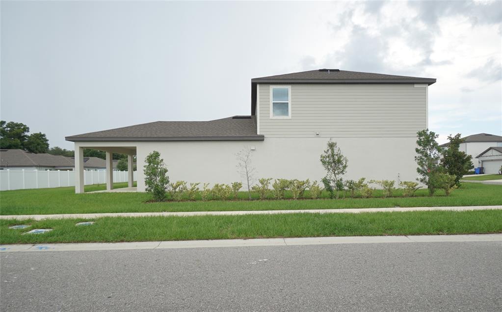 A modern kitchen features white cabinets, a central island with a sink, and tile flooring — 9667 SUMMERS CAY CIRCLE, THONOTOSASSA, FL