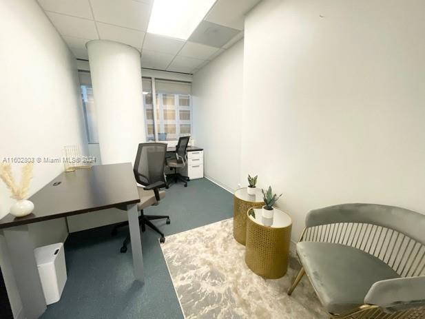 A small office features a dark desk, two chairs, and two gold side tables — 777 Brickell Ave, Miami FL 33131, MIAMI, FL