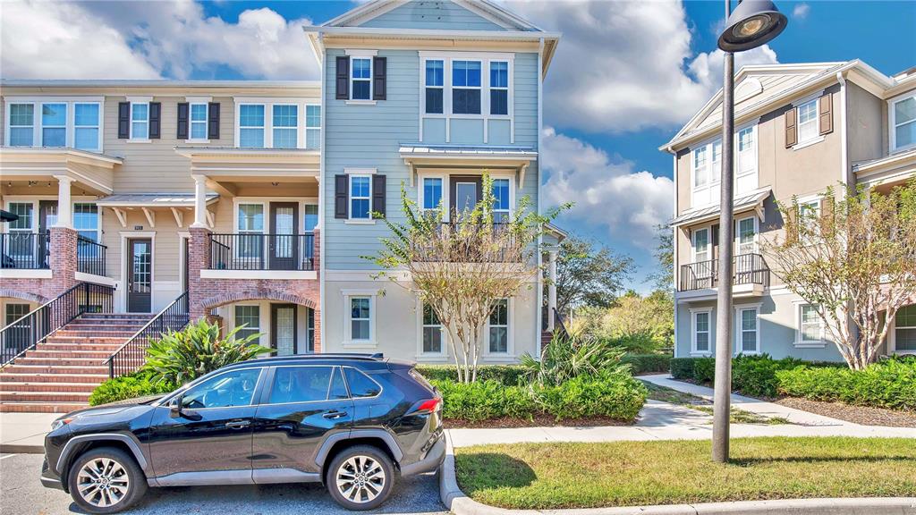 A black SUV is parked in front of a three-story townhouse with light blue siding — 921 TARAMUNDI DRIVE, OVIEDO, FL