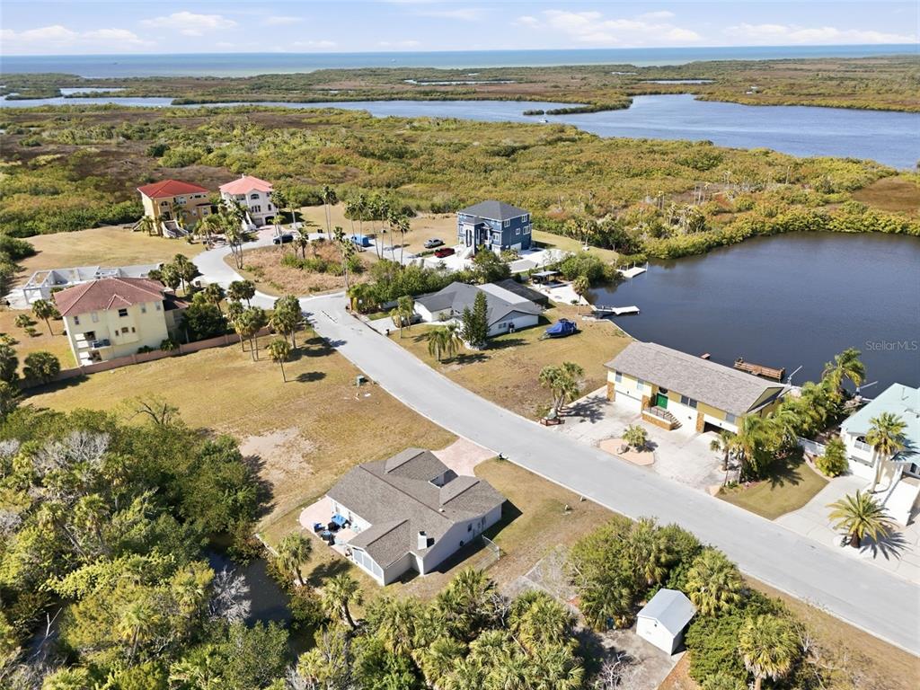An aerial view shows several houses situated near a body of water and marshland — 5728 SEABREEZE DRIVE, PORT RICHEY, FL