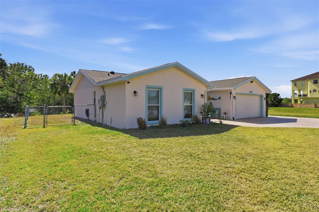 A single-story house with light-colored stucco walls, blue trim, and an attached garage — 5728 SEABREEZE DRIVE, PORT RICHEY, FL