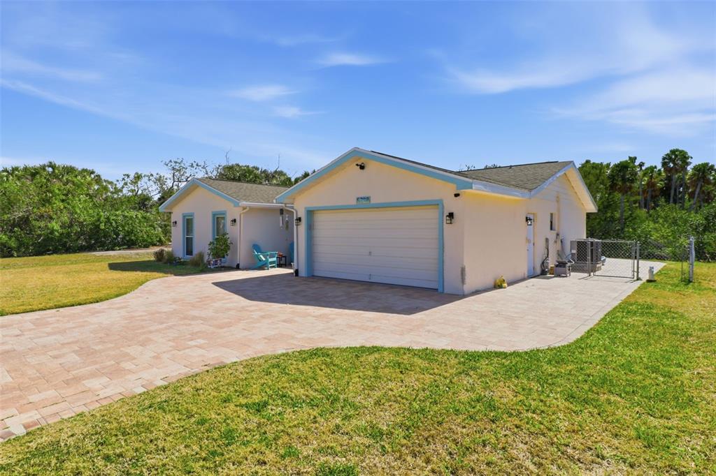 A light-colored house with a two-car garage and a paved driveway sits on a lawn — 5728 SEABREEZE DRIVE, PORT RICHEY, FL