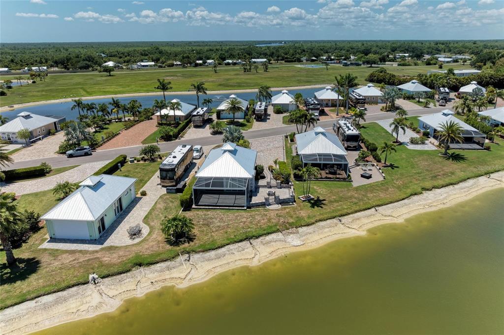 An aerial view shows several houses with metal roofs and RVs parked on waterfront lots — 8239 SW SAND CRANE CIRCLE LOT 11, ARCADIA, FL