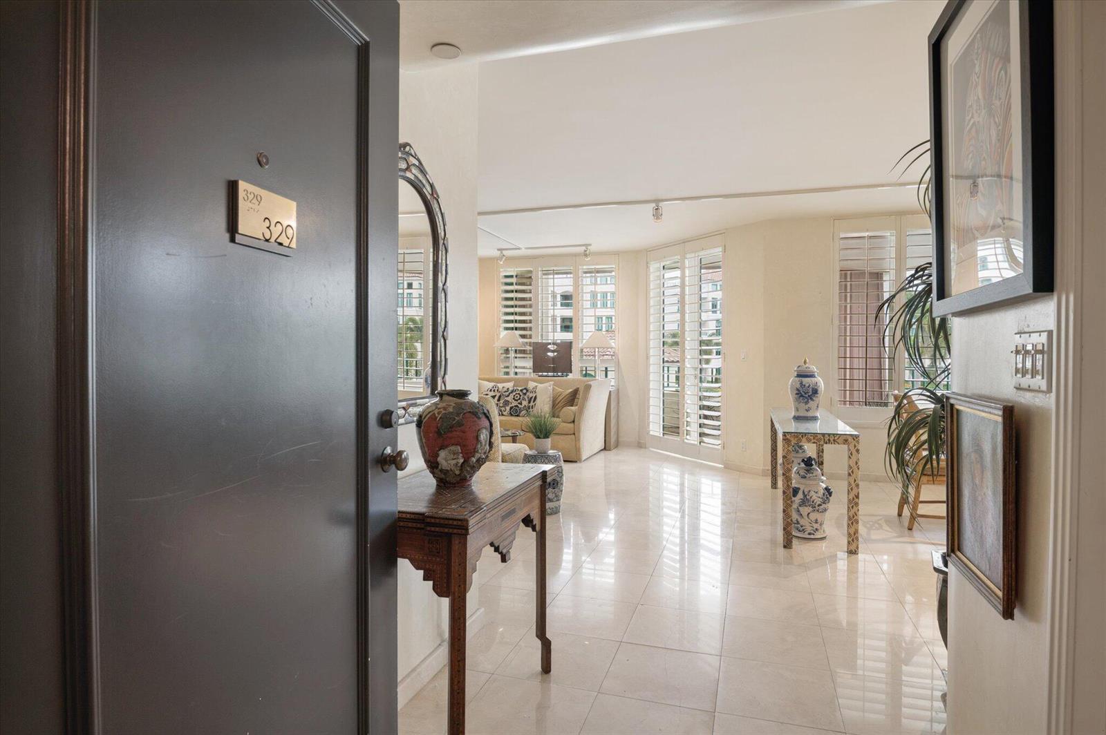 An entryway opens into a bright living area with tile floors and plantation shutters — 120 SE 5th Avenue # 329, Boca Raton FL 33432, BOCA RATON, FL