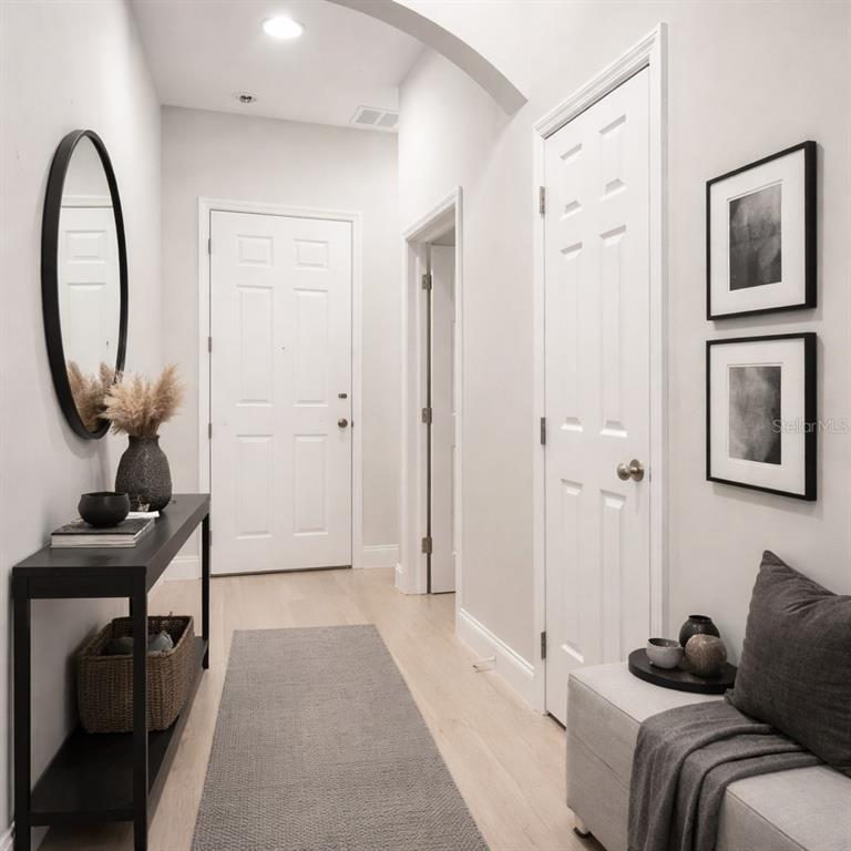A bright entryway features a console table, a bench, a mirror, and framed wall art — 827 DENNIS AVENUE, ORLANDO, FL