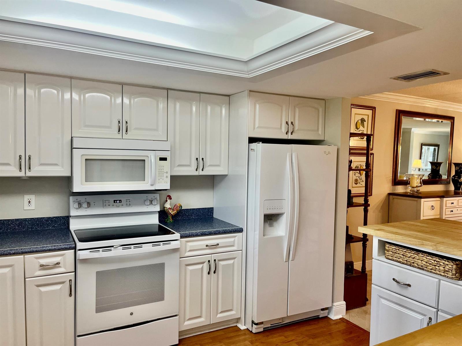 A kitchen features white cabinetry, a white stove and refrigerator, and blue speckled countertops — 145 Atlantis Boulevard, Atlantis FL 33462, ATLANTIS, FL
