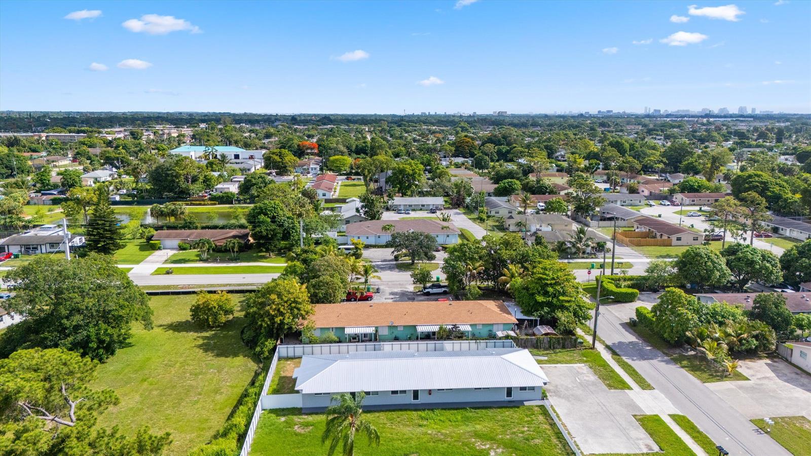 An aerial view shows a single-story building with a metal roof and surrounding residential neighborhood — 2807 Reo Lane # 1, Palm Springs FL 33461, PALM SPRINGS, FL