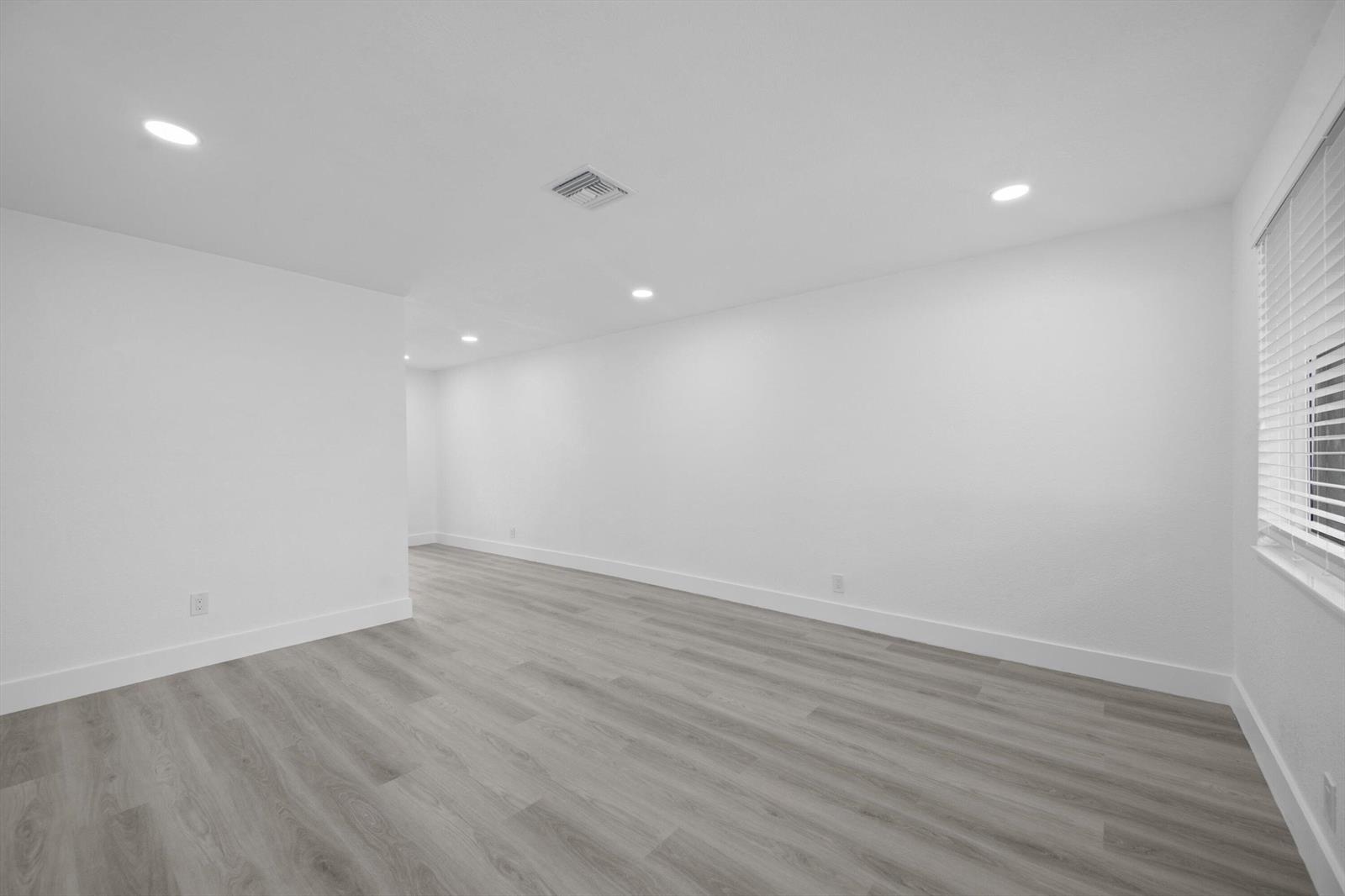 An empty room with white walls, recessed lighting, and light-colored wood-look flooring — 2807 Reo Lane # 1, Palm Springs FL 33461, PALM SPRINGS, FL