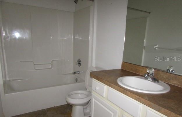 A bathroom featuring a white tub-shower combination, a toilet, and a vanity with a sink — 1142 MEADOWBEND DRIVE, LEESBURG, FL