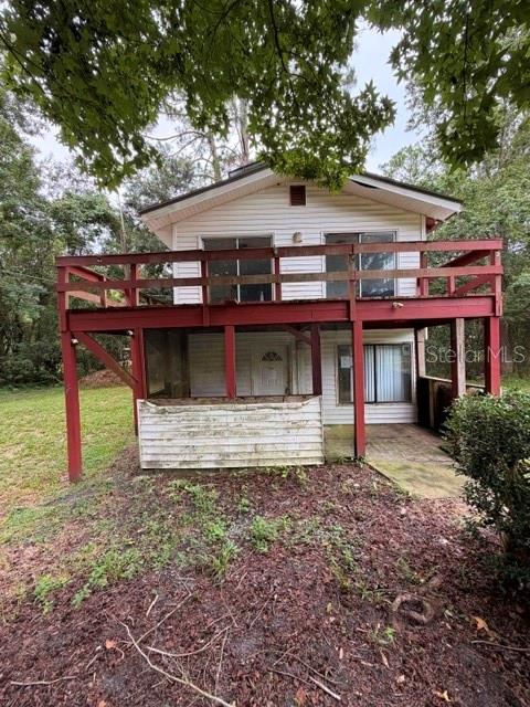 The exterior of a two-story house features a large red wooden deck and screened porch — 109 HANPARD LANE, PALATKA, FL