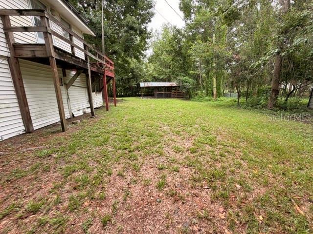 A wooden deck attached to the side of a house overlooks a grassy backyard — 109 HANPARD LANE, PALATKA, FL