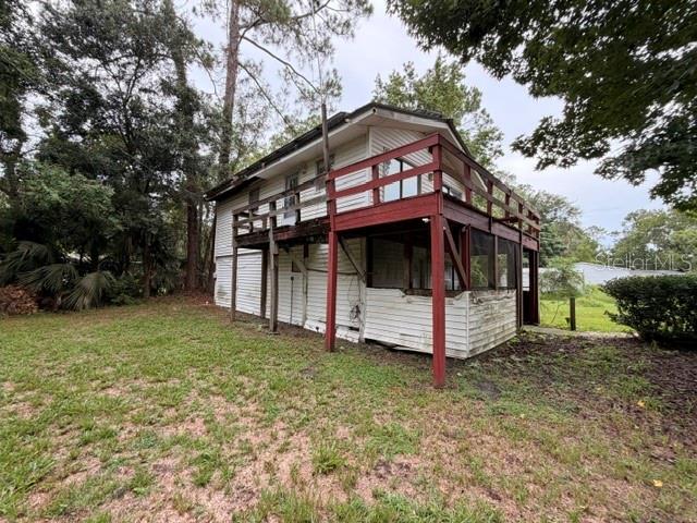 A two-story house with white siding and a red wooden deck and screened porch — 109 HANPARD LANE, PALATKA, FL