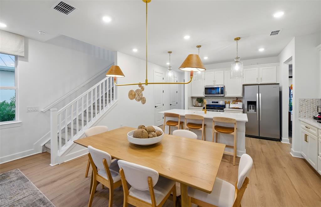 A dining area with a wooden table and chairs sits adjacent to a modern kitchen — 84 LAKE MANATEE DRIVE, PALM COAST, FL