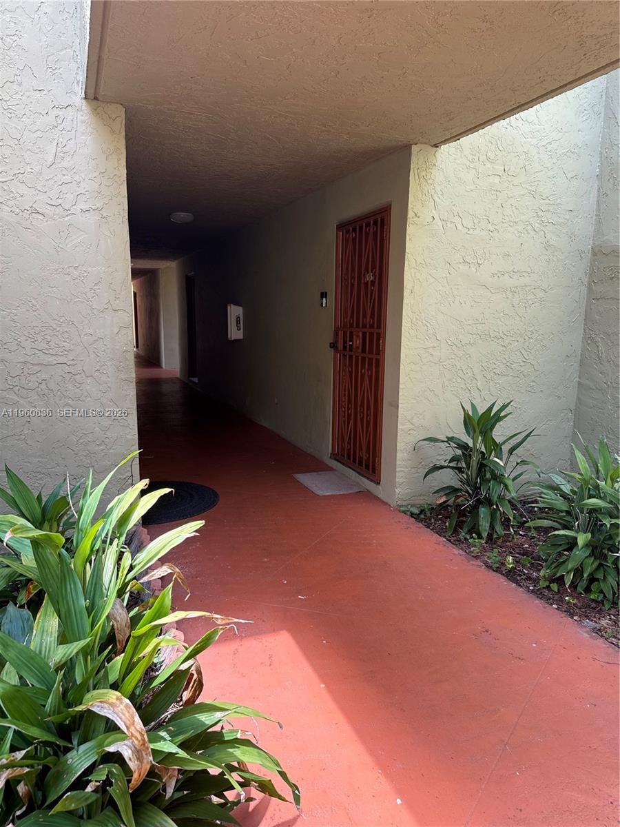 A covered outdoor walkway leads to a residential entrance with a metal security door — 9350 W Flagler St # 105A, Miami FL 33174, MIAMI, FL