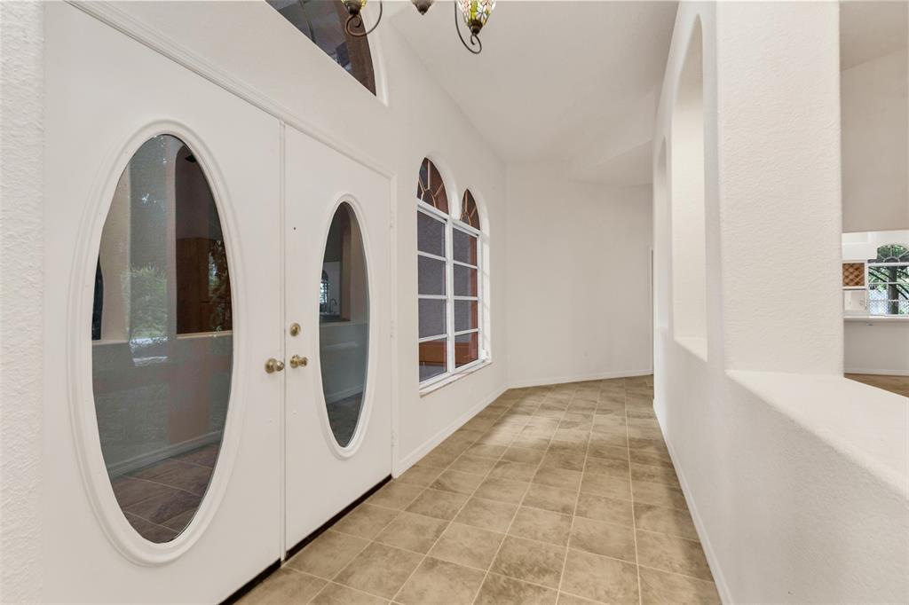 An entryway features white double doors with oval glass inserts, tile flooring, and arched windows — 4056 GINGOLD STREET, PORT CHARLOTTE, FL