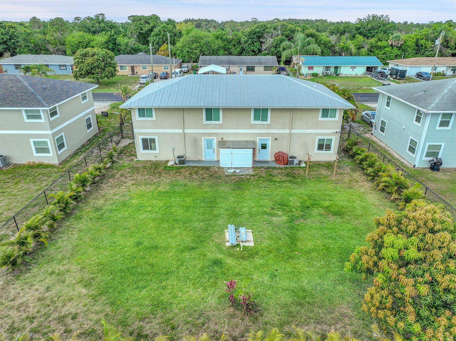 An aerial view shows the backyard of a two-story duplex with a metal roof — 2856 Harson Way, Fort Pierce FL 34946, FORT PIERCE, FL