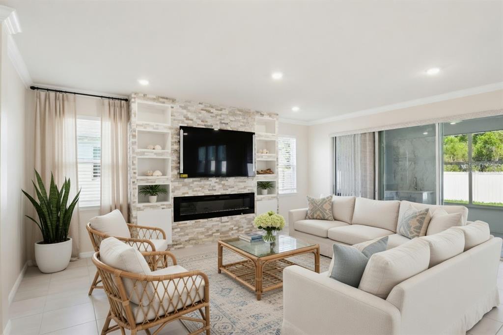 A living room features a stone fireplace wall with built-in shelving and a sectional sofa — 813 161ST STREET E, BRADENTON, FL