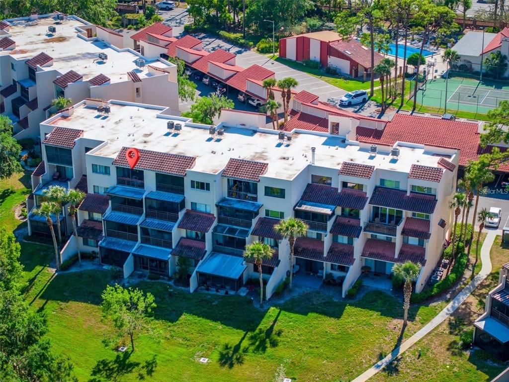 An aerial view shows a multi-story residential building with a red tile roof and balconies — 1162 CARMEL CIRCLE UNIT 440, CASSELBERRY, FL