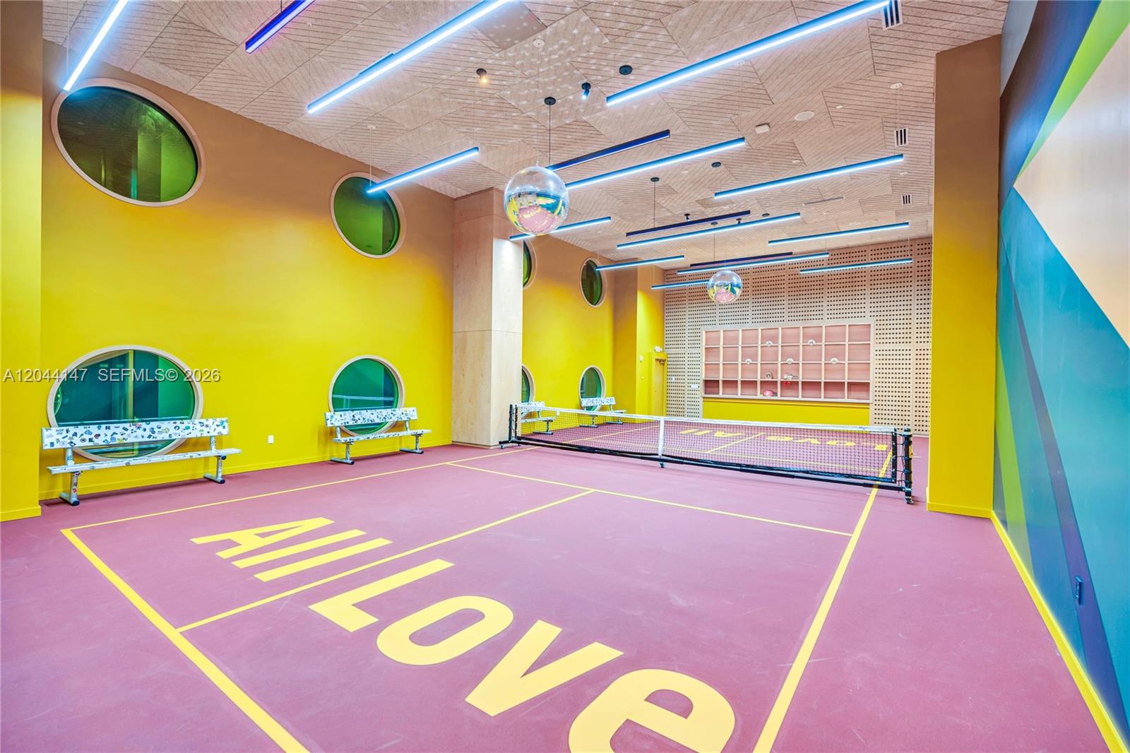An indoor pickleball court features yellow walls, circular windows, and a purple floor — 90 NE 32nd, Miami FL 33127, MIAMI, FL