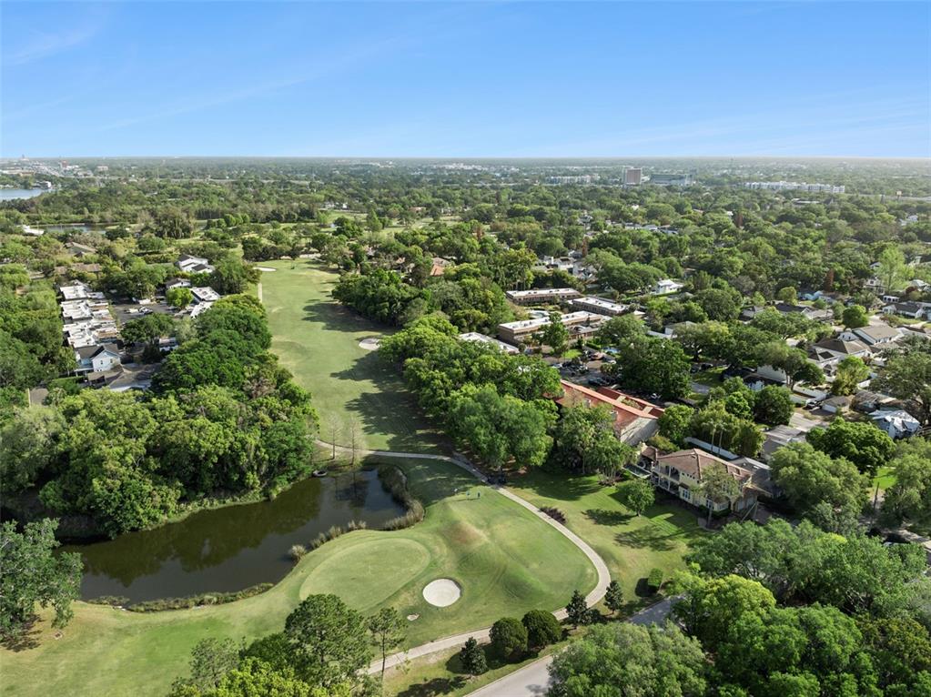 An aerial view shows a golf course fairway, a small pond, and surrounding residential buildings — 3104 HARRISON AVENUE UNIT 33, ORLANDO, FL
