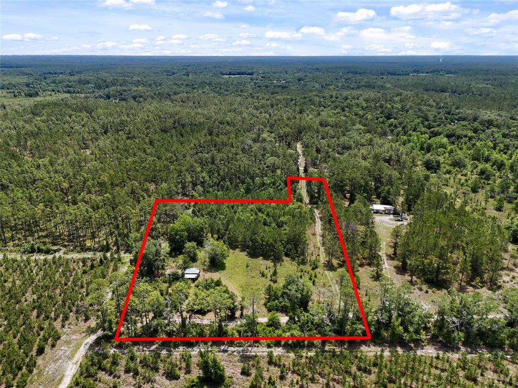 An aerial view shows a rectangular plot of land outlined in red containing a small structure — 2309 NE 73RD AVENUE, GAINESVILLE, FL