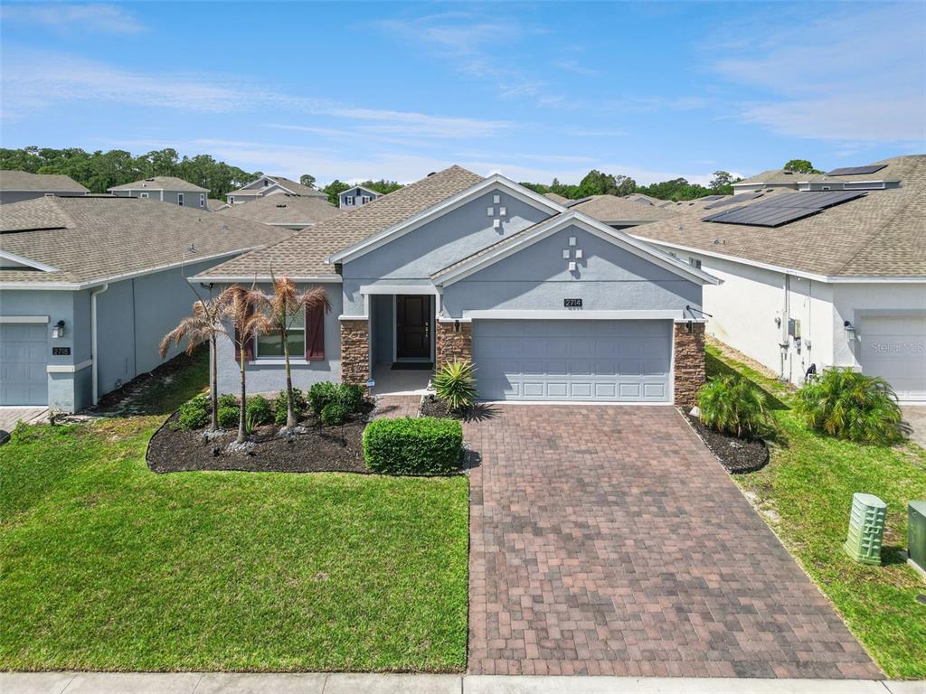 A single-story gray house features a paved driveway, stone accents, and a two-car garage — 2714 SLASH WAY, ST CLOUD, FL