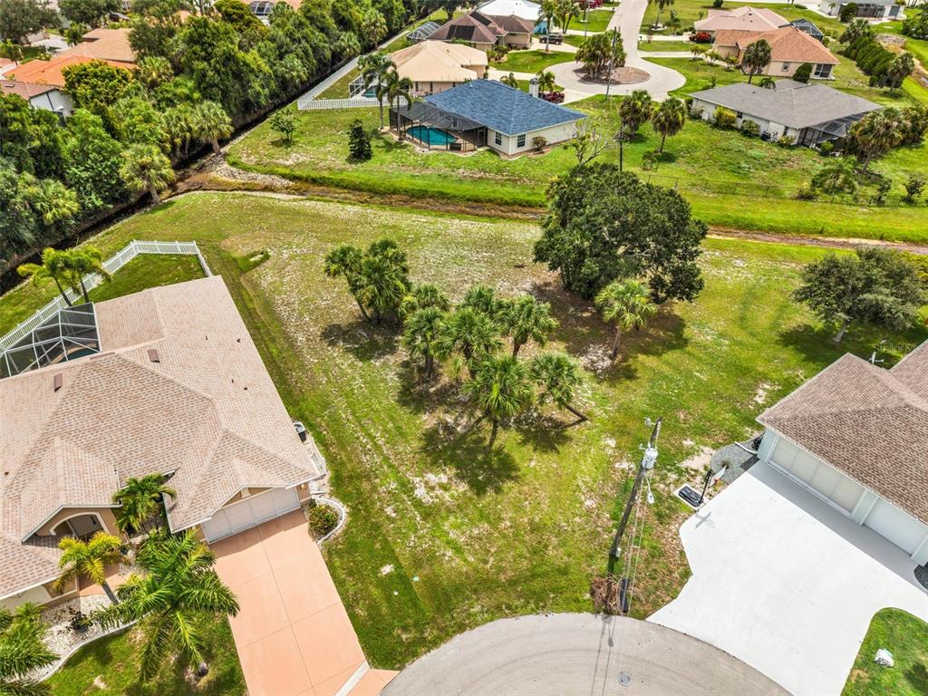 An aerial view shows a vacant residential lot situated between two houses in a neighborhood — 604 TRUMPET TREE, PUNTA GORDA, FL