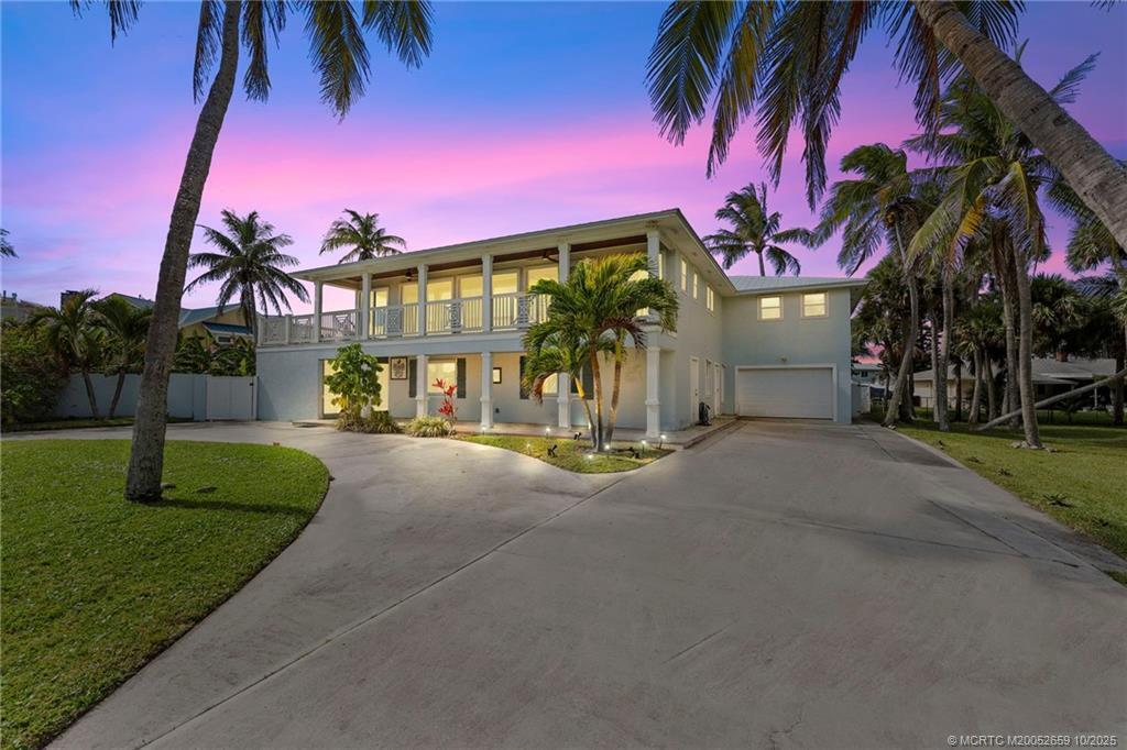 A two-story house with a large concrete driveway, palm trees, and a second-story balcony — 1911 Surfside Drive, Fort Pierce FL 34949, FORT PIERCE, FL