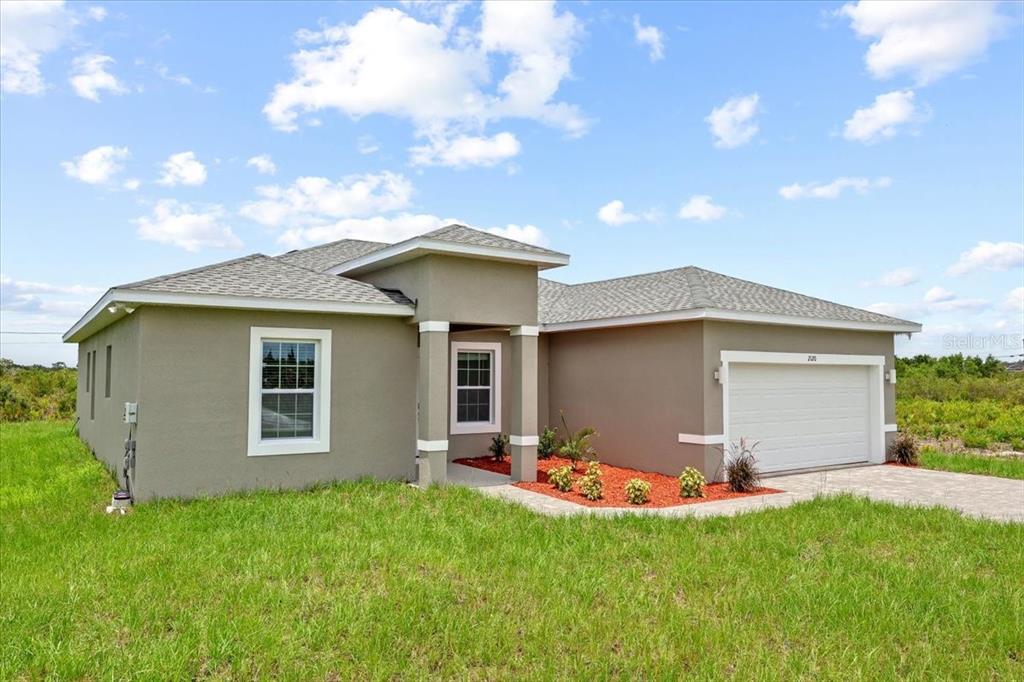 A single-story house with a tan stucco exterior, a gray shingled roof, and a garage — 2120 POINCIANA DRIVE, INDIAN LAKE ESTATES, FL