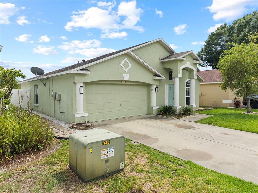 A light green single-story house with a two-car garage and a concrete driveway — 25237 SEVEN RIVERS CIRCLE, LAND O LAKES, FL