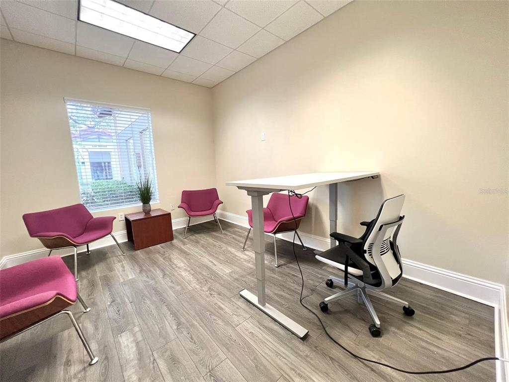 An office space features a standing desk, a rolling chair, and four purple accent chairs — 1550 W CLEVELAND STREET UNIT 11, TAMPA, FL