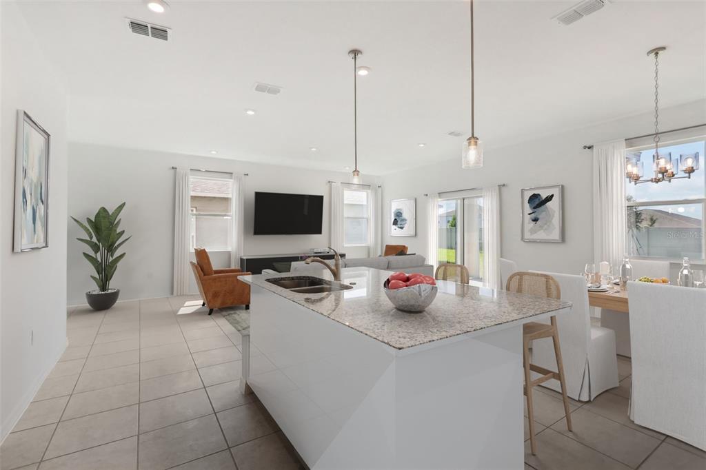 A kitchen island with granite countertops overlooks an open-concept living and dining area — 777 CASTLEFORD AVENUE NE, PALM BAY, FL