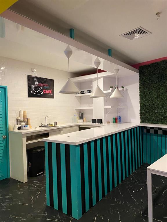 A cafe interior features a white counter, teal and black striped base, and pendant lighting — 88 CALLE REINA ST, PONCE, PR