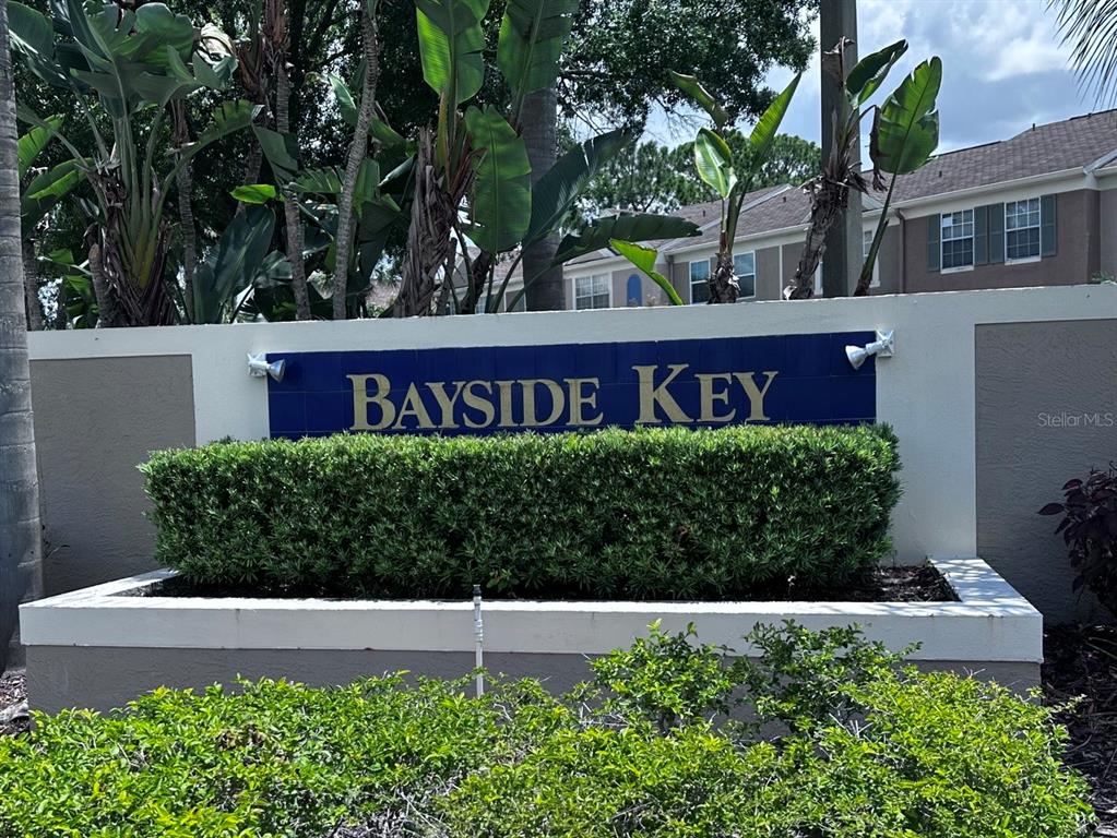 A Bayside Key community sign sits in front of a hedge and apartment buildings — 6211 BAYSIDE KEY DRIVE, TAMPA, FL