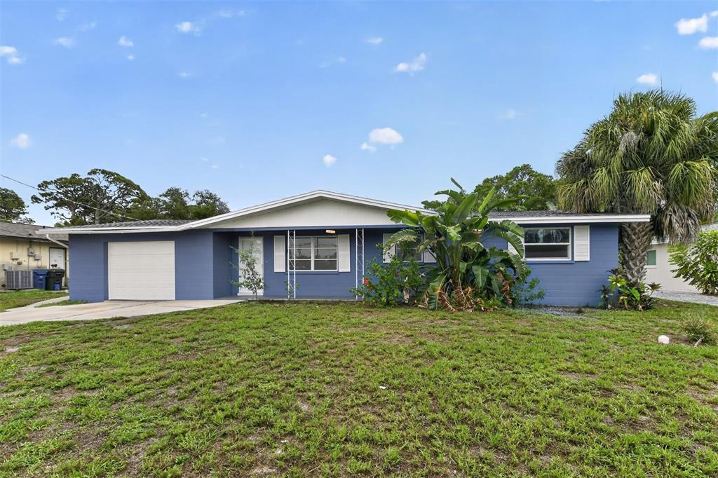A blue, single-story ranch-style house with a white garage door and a front lawn — 3238 SAVAGE ROAD, SARASOTA, FL