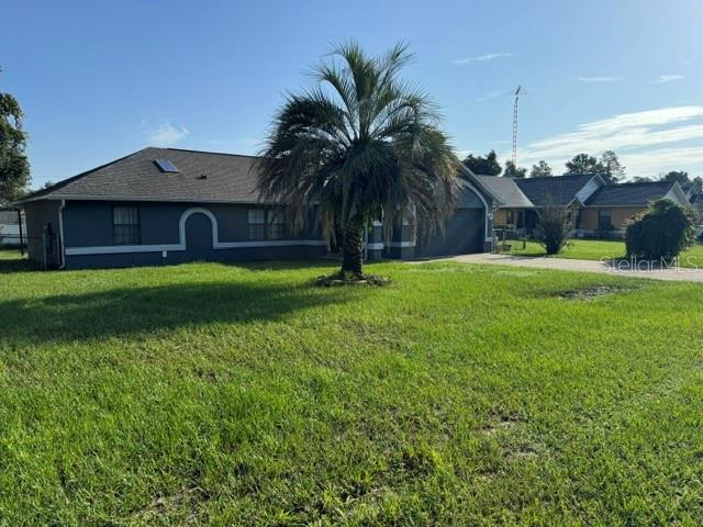 A gray single-story house with a palm tree in the front yard under a blue sky — 13640 SW 40TH AVENUE ROAD, OCALA, FL