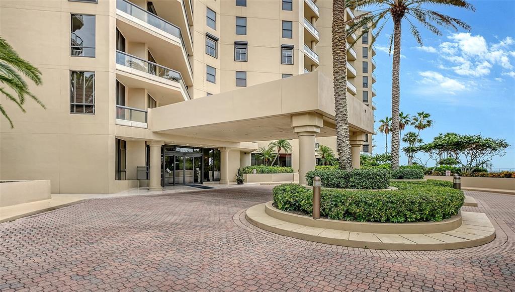 The exterior of a multi-story building features a covered entrance and a circular driveway — 1241 GULF OF MEXICO DRIVE UNIT 303, LONGBOAT KEY, FL