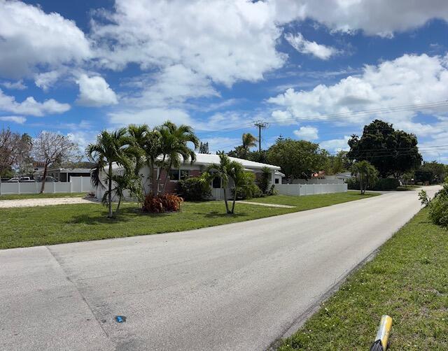 A single-story house with a white roof and palm trees sits beside a paved road — 1107 S 15th Avenue, Hollywood FL 33020, HOLLYWOOD, FL