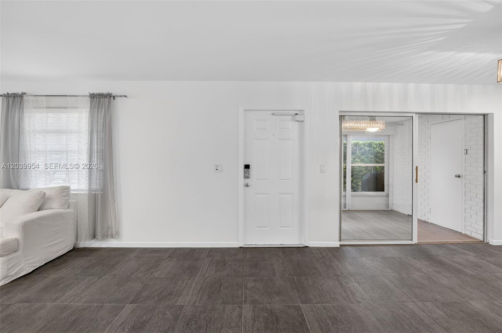 A kitchen features white cabinets, granite countertops, a stainless steel refrigerator, and gray tile flooring — 10125 S 42nd Ave S # 151, Boynton Beach FL 33436, BOYNTON BEACH, FL