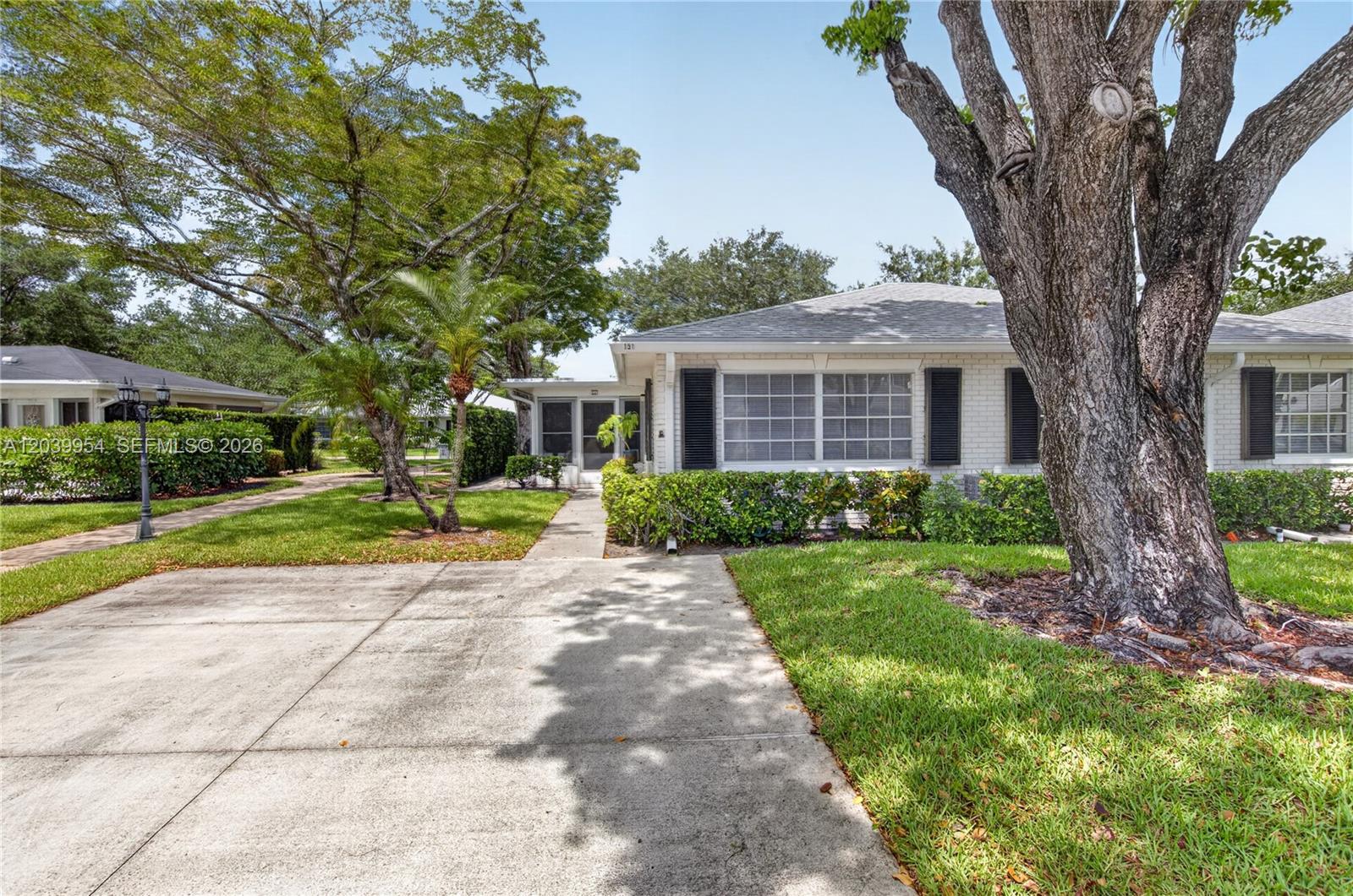 A kitchen features white cabinets, stainless steel appliances, granite countertops, and a subway tile backsplash — 10125 S 42nd Ave S # 151, Boynton Beach FL 33436, BOYNTON BEACH, FL