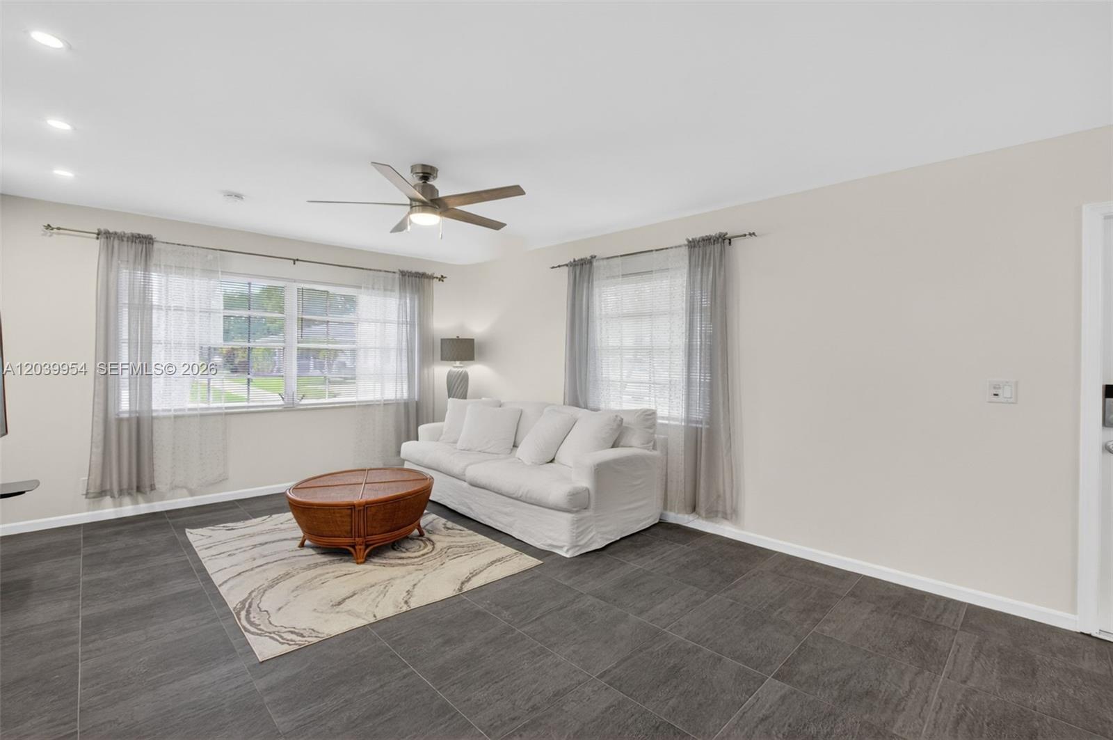 A kitchen with white cabinets, granite countertops, a stainless steel refrigerator, and dark tile flooring — 10125 S 42nd Ave S # 151, Boynton Beach FL 33436, BOYNTON BEACH, FL