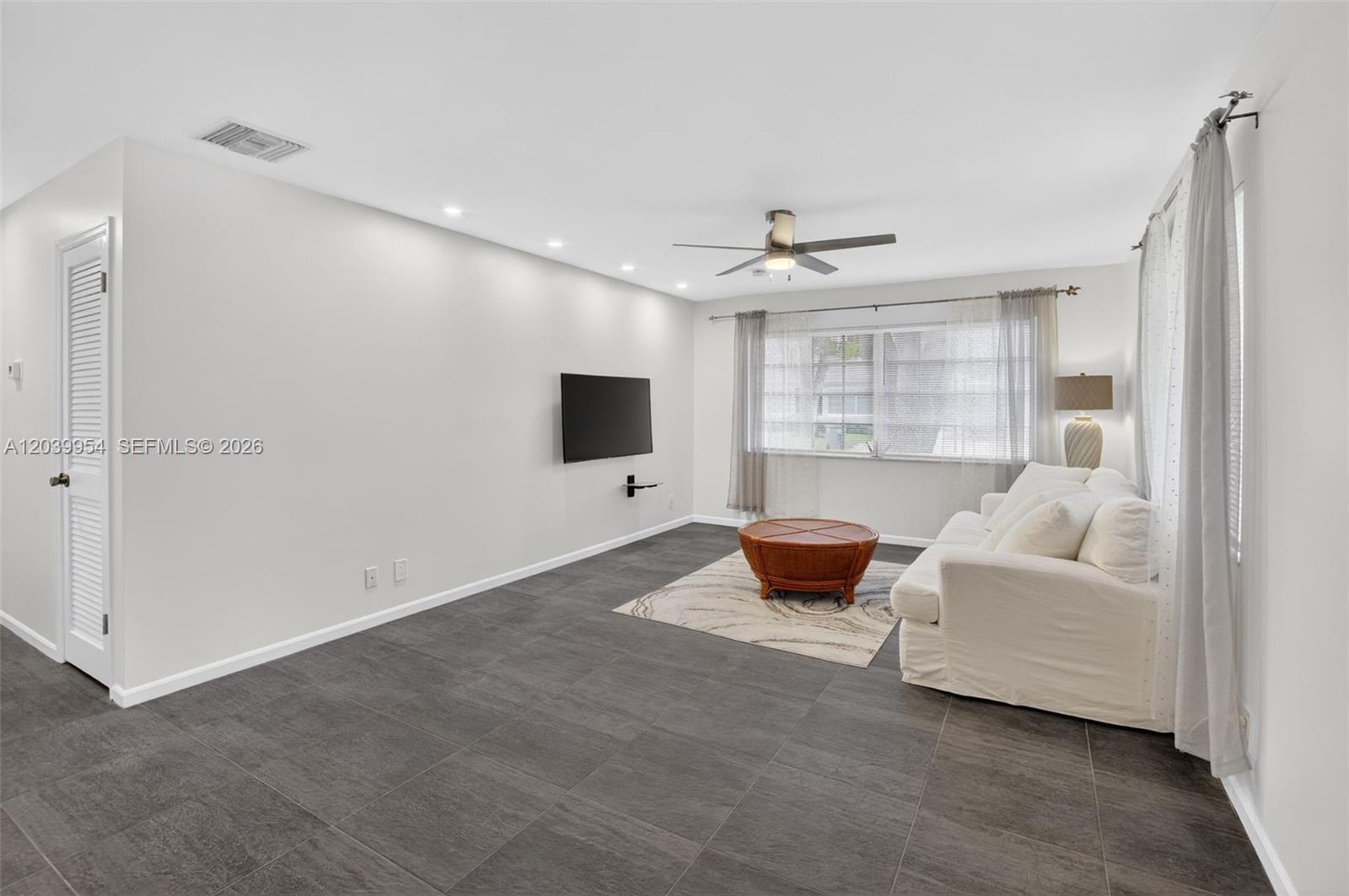 A white brick house exterior features a screened-in porch, a front door, and landscaping — 10125 S 42nd Ave S # 151, Boynton Beach FL 33436, BOYNTON BEACH, FL