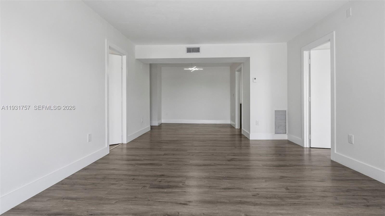 An empty room features white walls, wood-look flooring, and a recessed ceiling light fixture — 4158 Inverrary Dr # 409, Lauderhill FL 33319, LAUDERHILL, FL