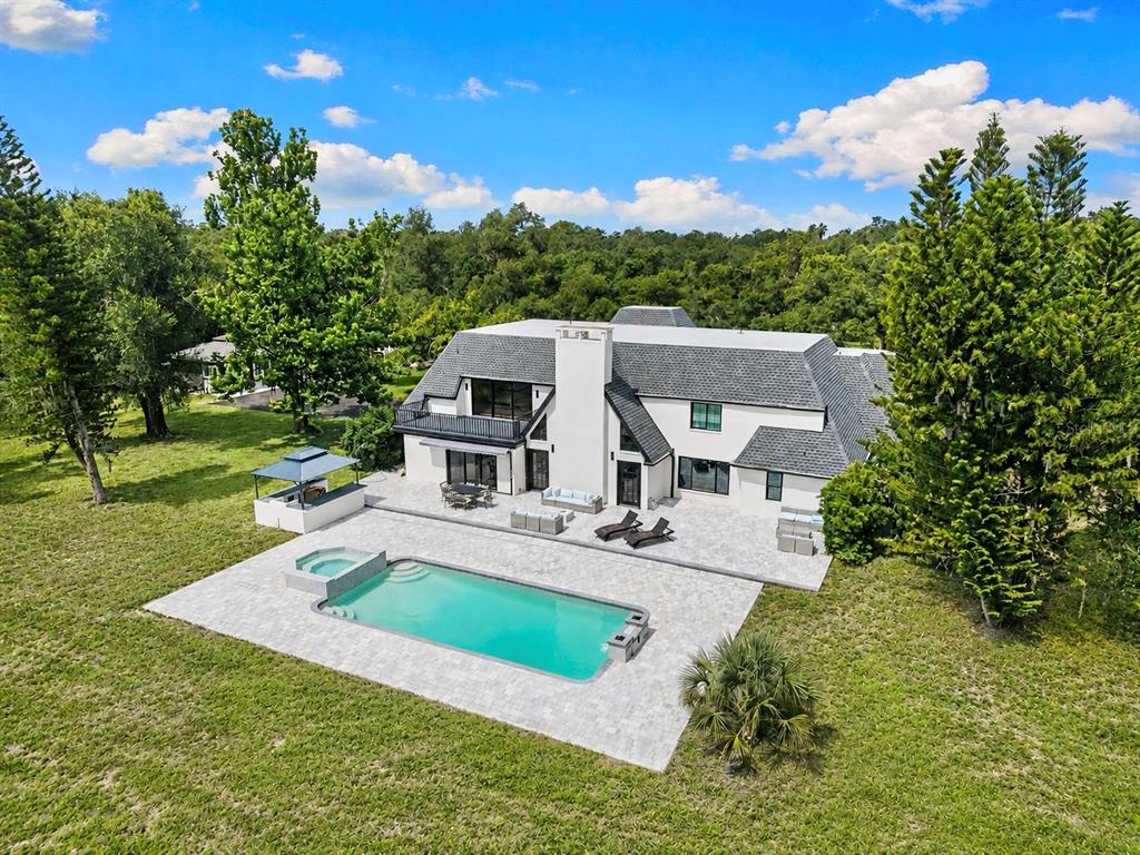 An aerial view of a white two-story house with a pool and patio area — 7351 IGUANA DRIVE, SARASOTA, FL