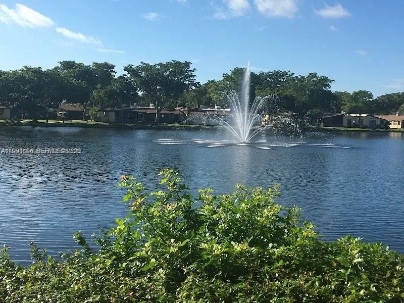A water fountain sprays in the center of a lake surrounded by trees and houses — 200 Berkley Rd # 123, Hollywood FL 33024, HOLLYWOOD, FL