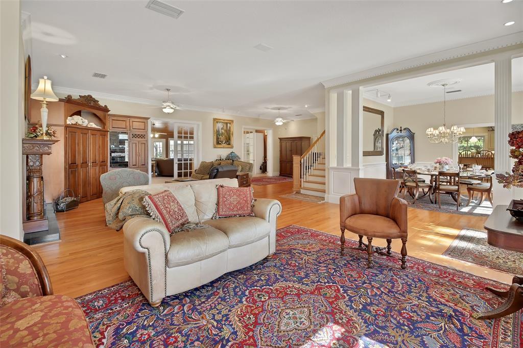 A spacious living room features hardwood floors, a large area rug, and a dining area — 150 LAKE WINNEMISSETT DRIVE, DELAND, FL