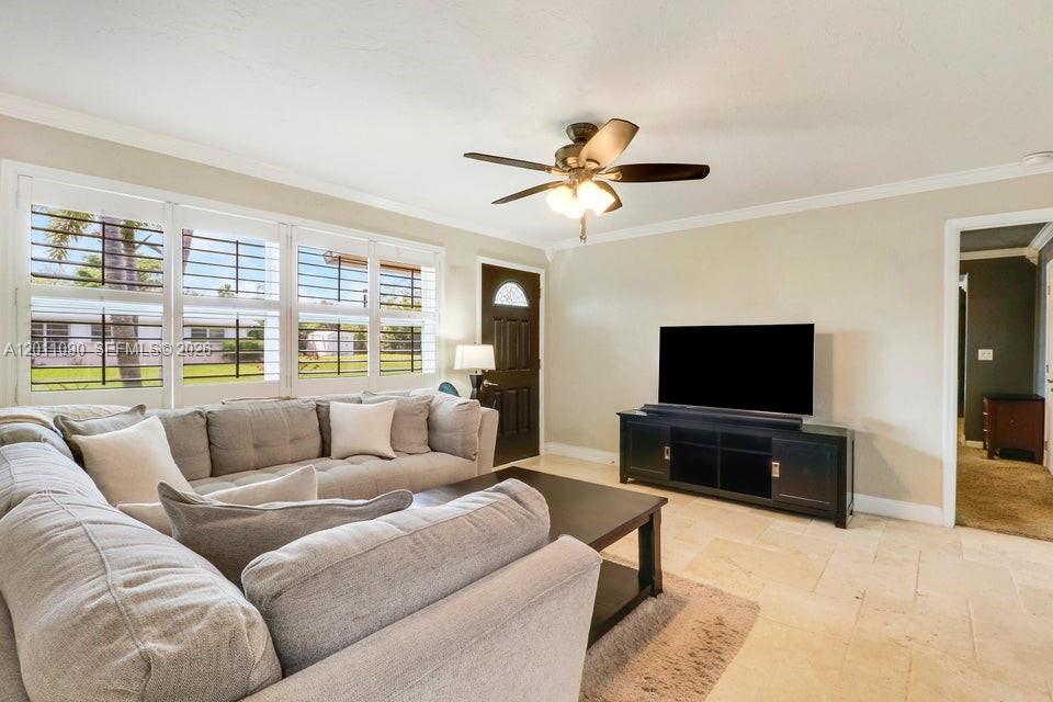 A living room features a large sectional sofa, a television on a console, and tile flooring — 19049 SE Robert Drive, Jupiter FL 33469, JUPITER, FL