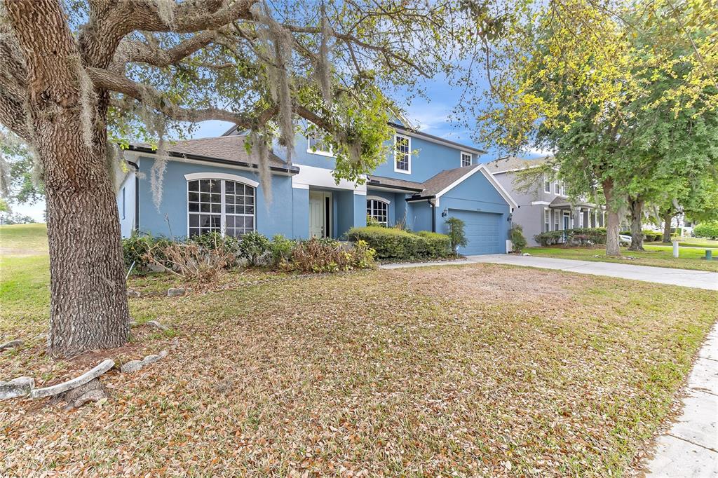 A two-story blue house with a garage and a large tree in the front yard — 3323 FAWNWOOD DRIVE, OCOEE, FL