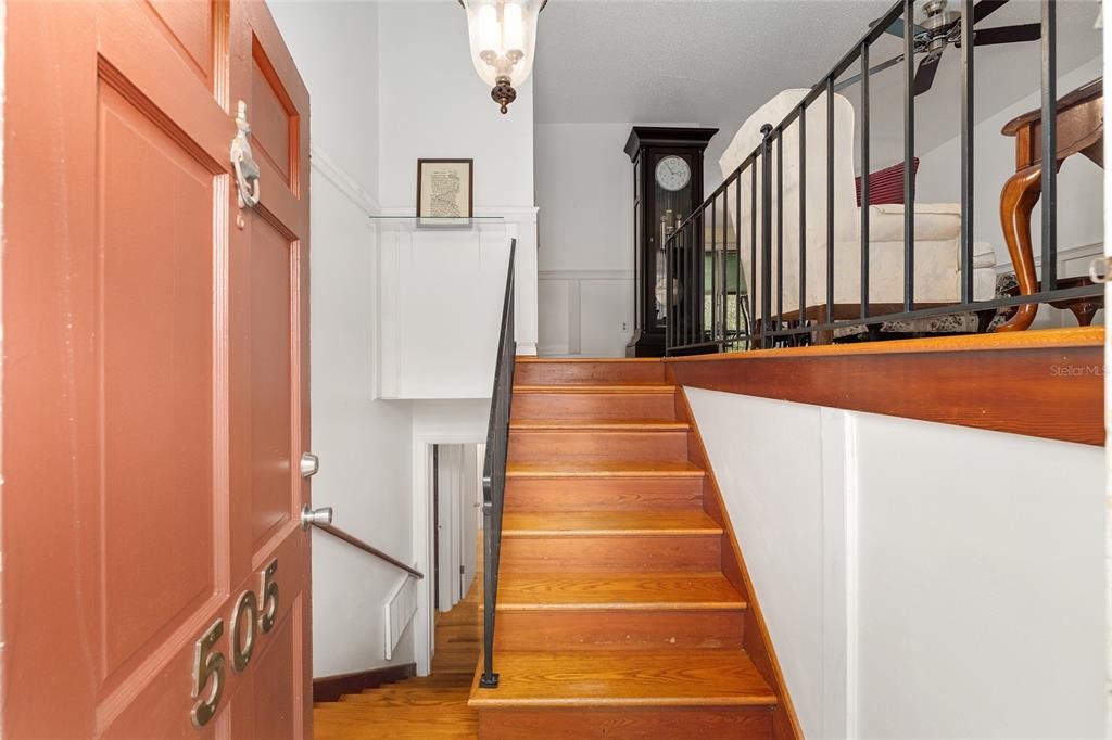 An entryway features a staircase leading up to a landing with a grandfather clock — 505 NW 37TH PLACE, GAINESVILLE, FL