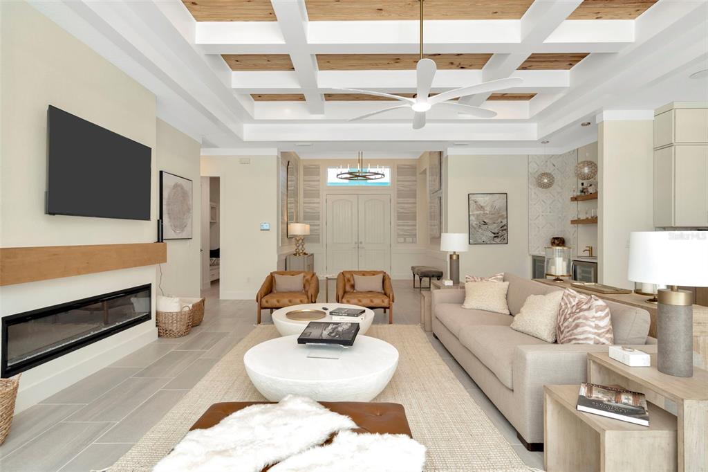 A living room features a coffered ceiling, a linear fireplace, and neutral-toned furniture — 12714 IVORY TUSK LANE, SPRING HILL, FL